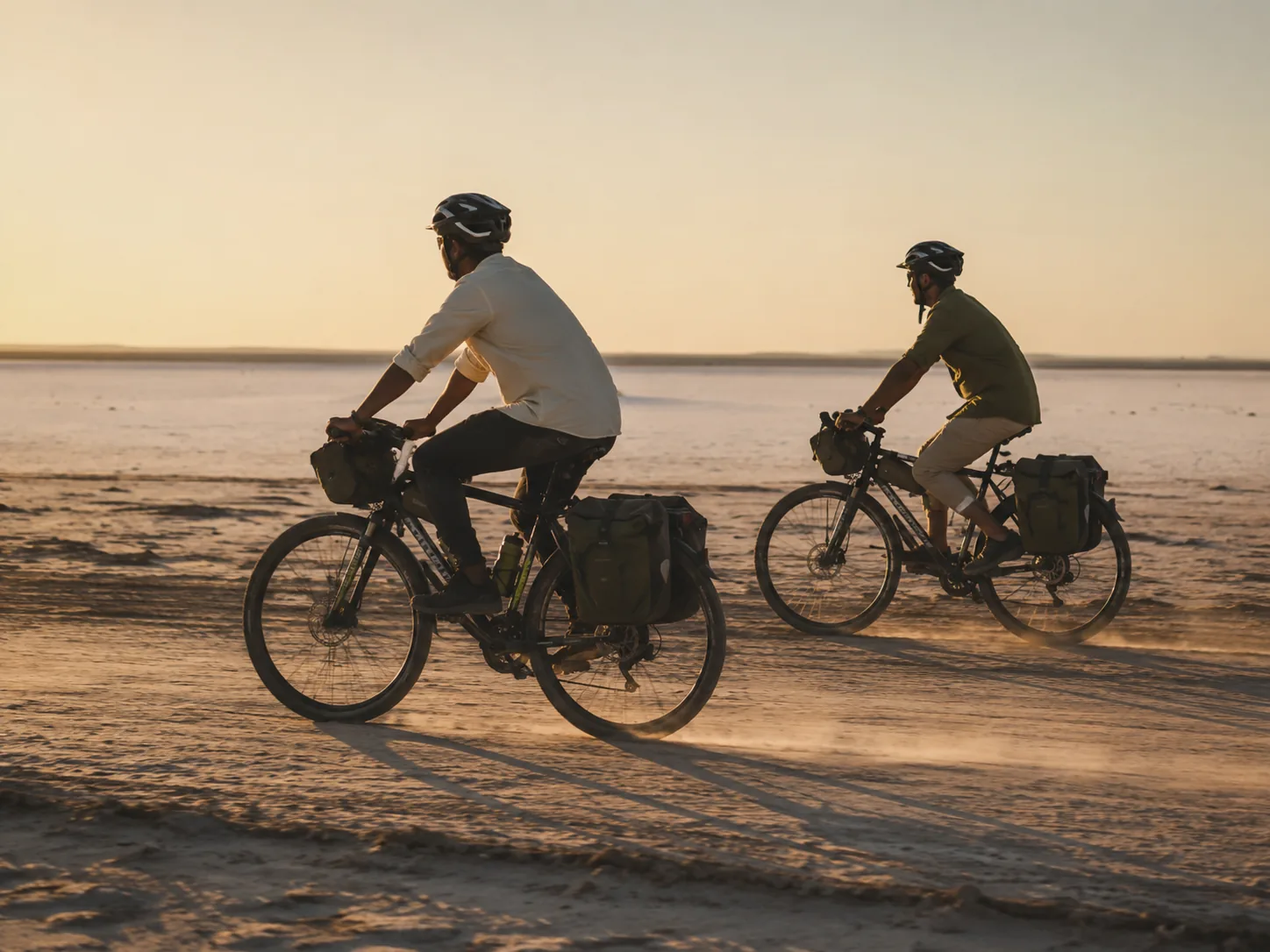 Cyclists crossing the dusty Kutch plains on a guided bicycle desert tour at Rann Utsav Dhordo